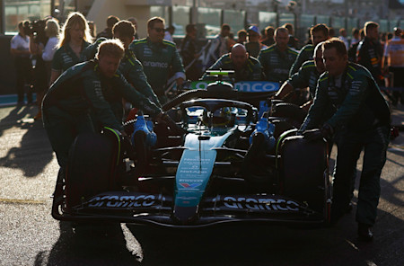 Fernando's mechanics push his car into position on the grid
