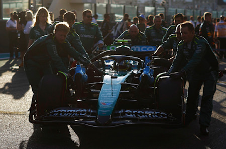 Fernando's mechanics push his car into position on the grid