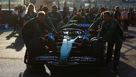 Fernando's mechanics push his car into position on the grid