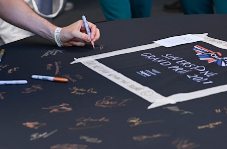 Guests sign the AMR car cover
