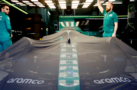 Rise and shine: the team lifts the covers off the AMR22 on race day