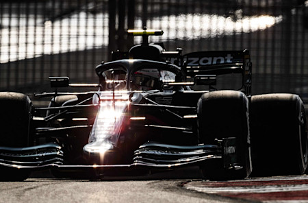 The sun bounces off the AMR21 as the sun sets ahead of the all-important FP2 session